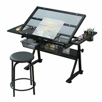 Adjustable drafting table with art supplies and stool.