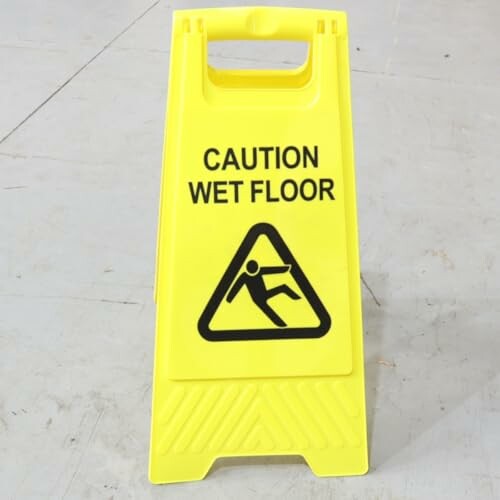 Yellow caution wet floor sign on a light floor.