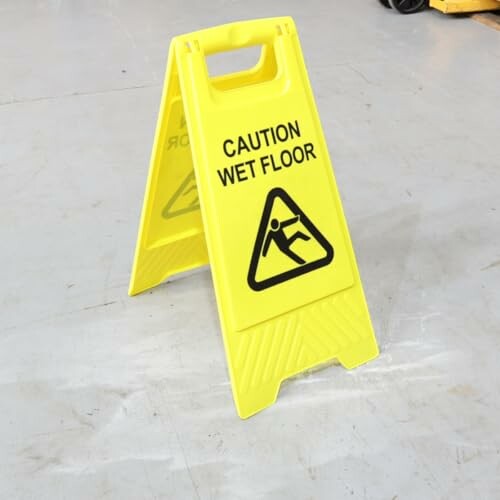 Yellow caution wet floor sign on a gray surface.