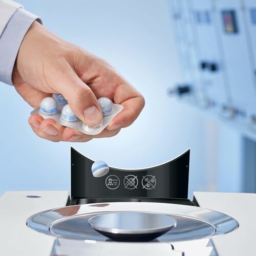 Hand inserting detergent pod into a washing machine