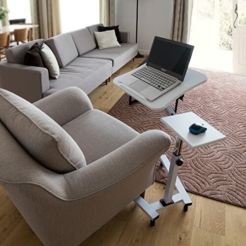 Cozy living room with a laptop on an adjustable desk beside a chair.