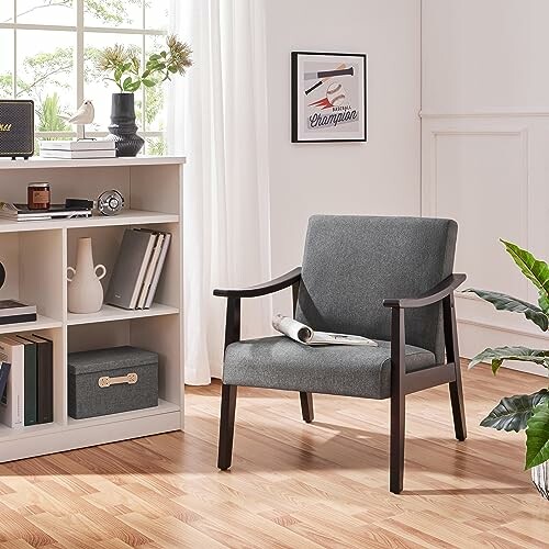 Modern gray armchair in a stylish room with bookshelf and decor.