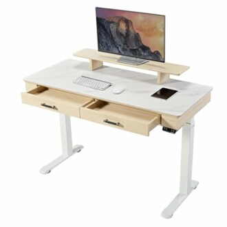 Modern standing desk with monitor, keyboard, and drawers.