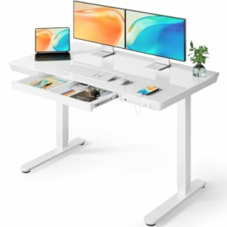 Modern white standing desk with monitors, laptop, and accessories.