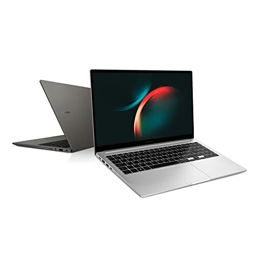 Two open laptops with sleek design and screens displaying abstract graphics.